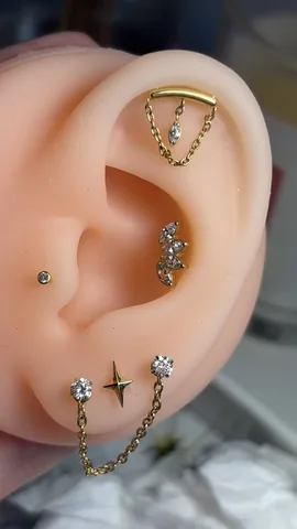 Composición de piercings en la oreja con cadena