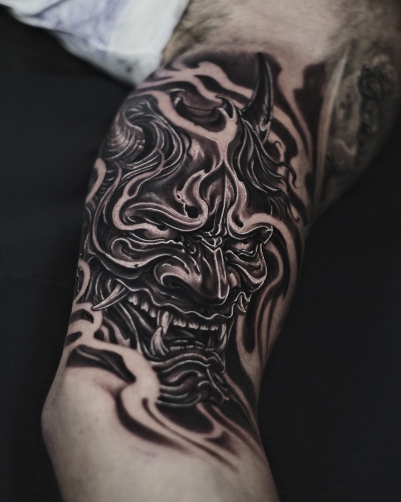 Tatuaje blackout de ondas ornamentales en negro solido, en el brazo