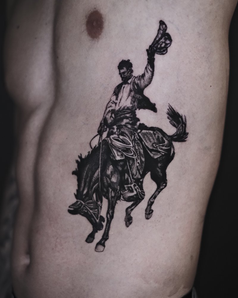 Tatuaje blackwork de un jinete a caballo en el costado