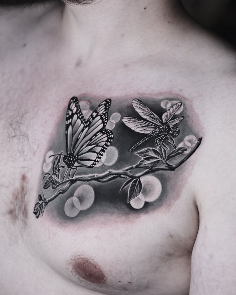 Tatuaje de línea fina con una rama de cerezo, corazones rojos y una mariposa en el pecho