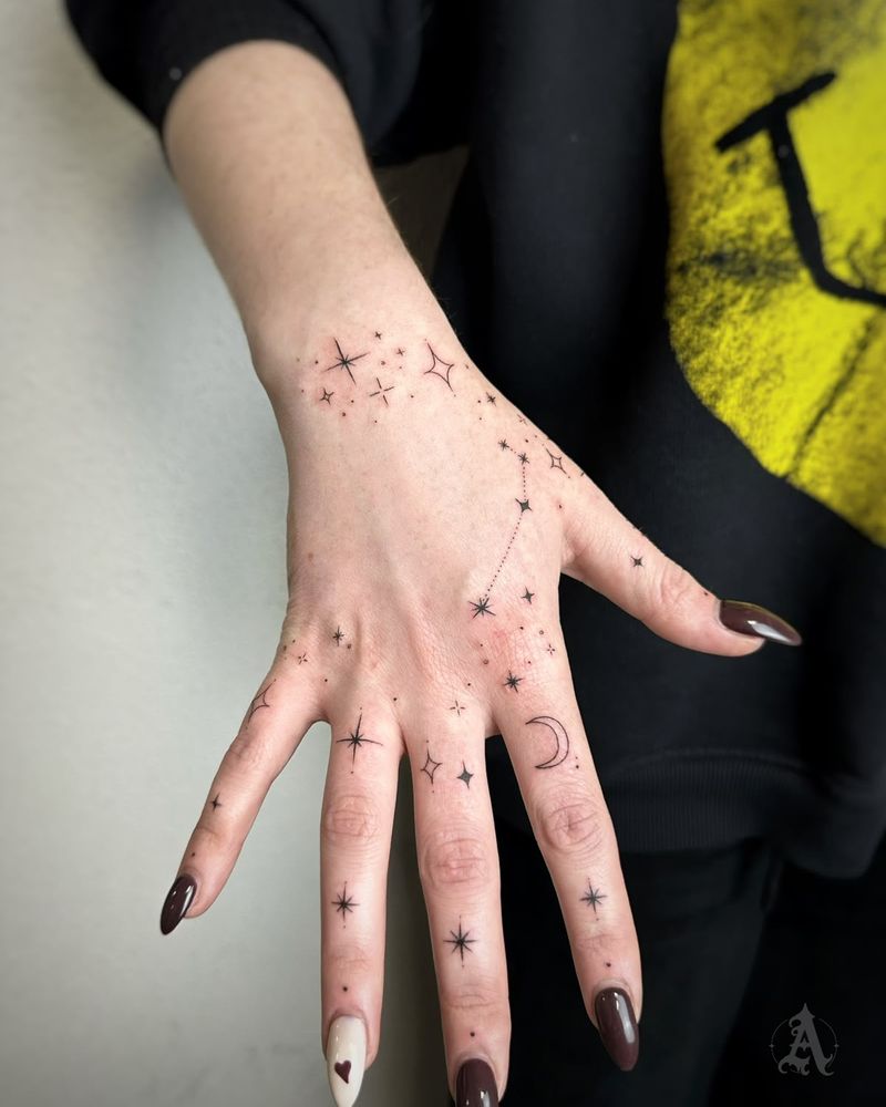 Tatuaje de estrellas y puntos en la mano y los dedos, fine line en negro y gris