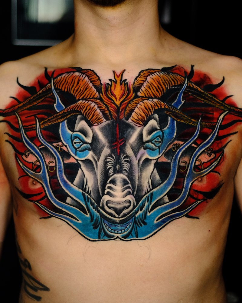 Tatuaje a color de una cabeza de tigre con llamas azules y rojas en el pecho
