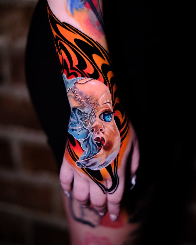 Tatuaje a color de un personaje de dibujos animados en el dorso de la mano