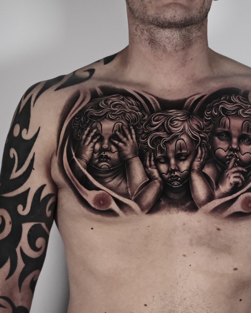 Tatuaje realista en negro y gris de tres querubines en el pecho