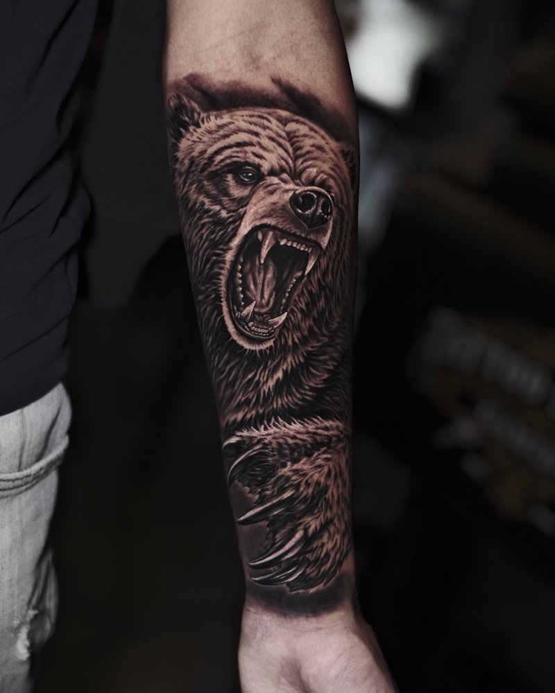 Tatuaje realista en negro y gris: rostro con una rosa y burbujas, en el antebrazo